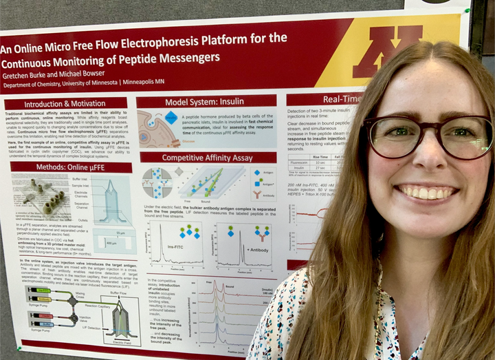 Gretchen stands in front of her research poster.